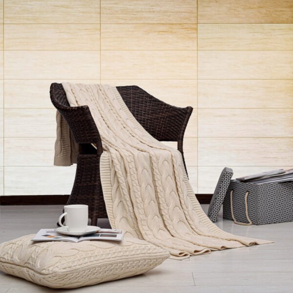 Cable Κουβέρτα Καναπέ Natural πλεκτή απλωμένη σε καρέκλα με μαξιλάρι δαπέδου
