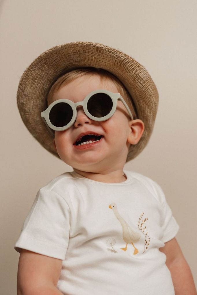 Παιδικά Γυαλιά Ηλίου UV400 Green από πλαστικό με δείκτη προστασίας UV400 φορεμένα από ένα παδιάκι με καπέλο