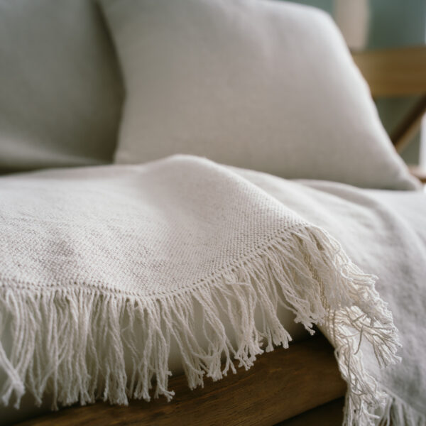 Mewa Ριχτάρι Sail Cloth Beige 182/06 3 Διαστάσεις με κρόσι στρωμένο σε καναπέ με μαξιλάρι