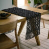 Sahara Runner 193/14 Stone Black στρωμένο σε τραπέζι από χειροποίητο macrame από χρωματιστό βαμβακερό νήμα