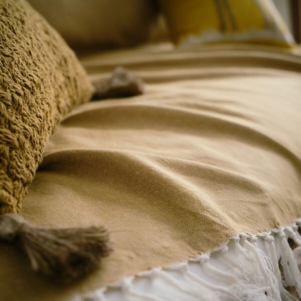 Eartha Ριχτάρι Honey Gold 372/04 3 Διαστάσεις με κρόσια στρωμένο σε καναπέ με μαξιλάρι