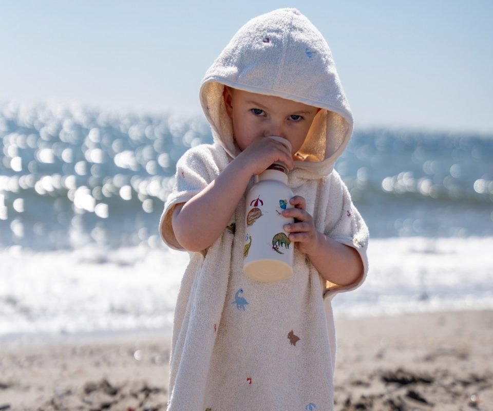 Dino Beach Stainless Steel Water Bottle, το οποίο κρατάει ένα παιδάκι