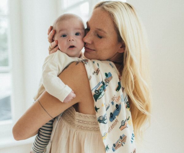 Grand Prix Bamboo Κουβέρτα Swaddle απλωμένη στον ώμο μιας γυναίκας