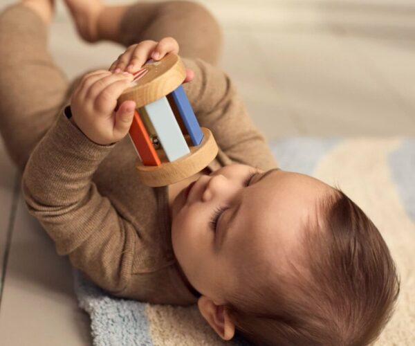 Play Set My First Wooden Sensory Toys, με τα οποία παίζει ένα βρέφος
